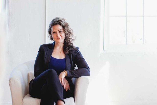 Lee-Anne Reuber, founder of Sekond Skin Society, seated by a bright window.